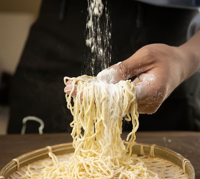 厨师撒粉抖开新鲜制作的拉面面条