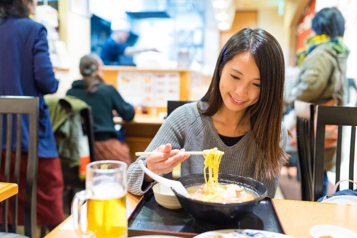食客在拉面店里夹起一筷子拉面
